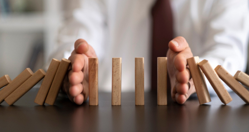 two hands holding up wooden domino blocks
