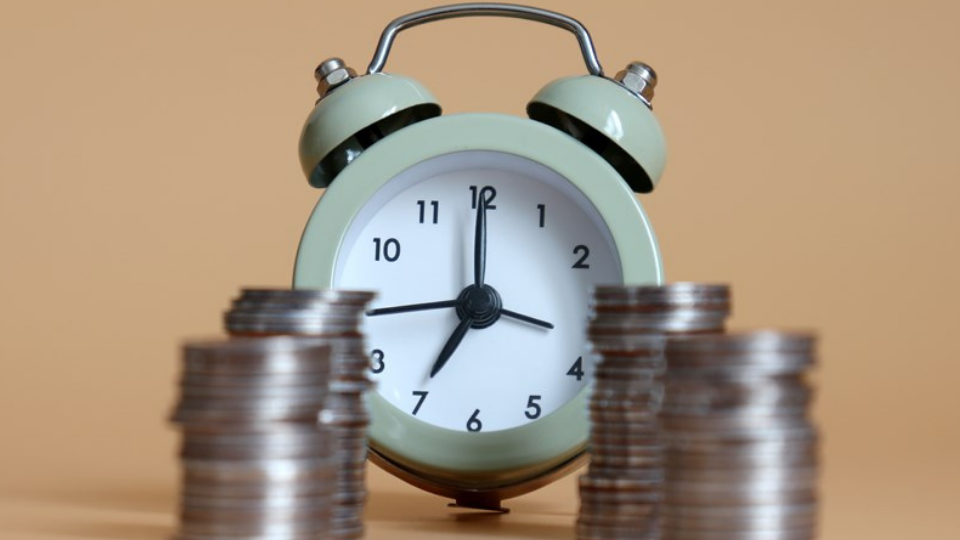 Piles of coins and an alarm clock