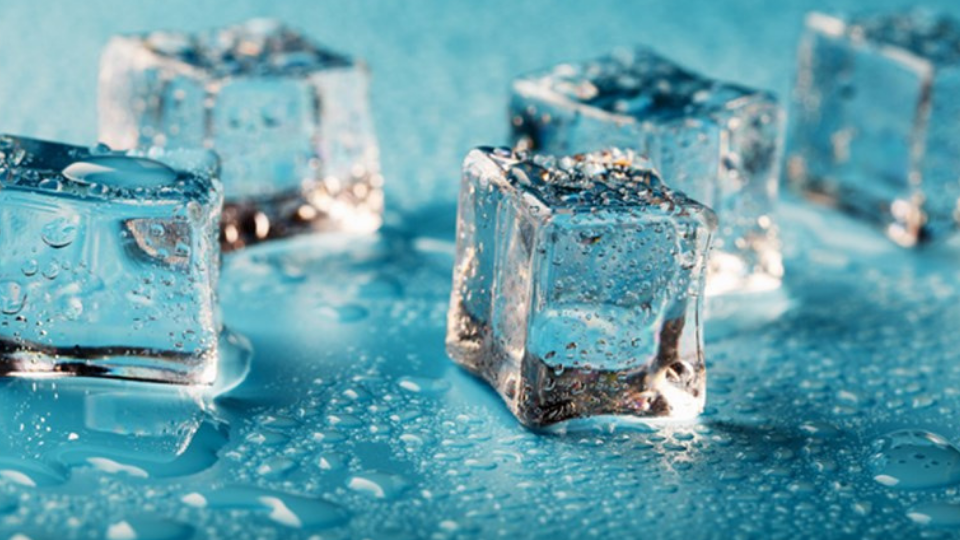 Ice cubes are scattered with water drops scattered on a blue background
