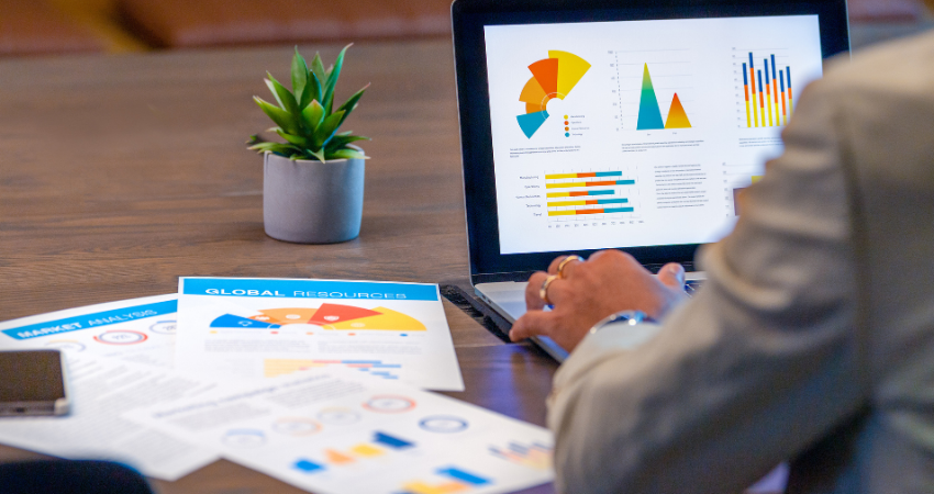 Close up of businessman using a laptop with financial data with graphs and charts on a laptop computer