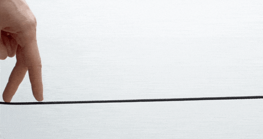 Balance and concentration concept. A man's hand walks on a rope on a white background