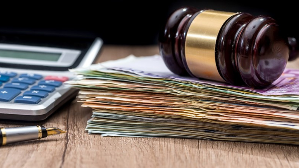 Euro banknotes, gavel, calculator and pen