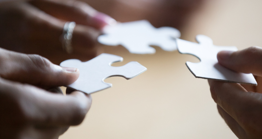 Close up of associates holding puzzle pieces
