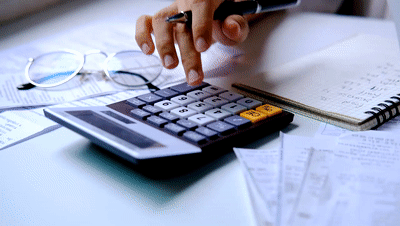 Stressed young woman checking bills, taxes, bank account balance and calculating expenses in the living room