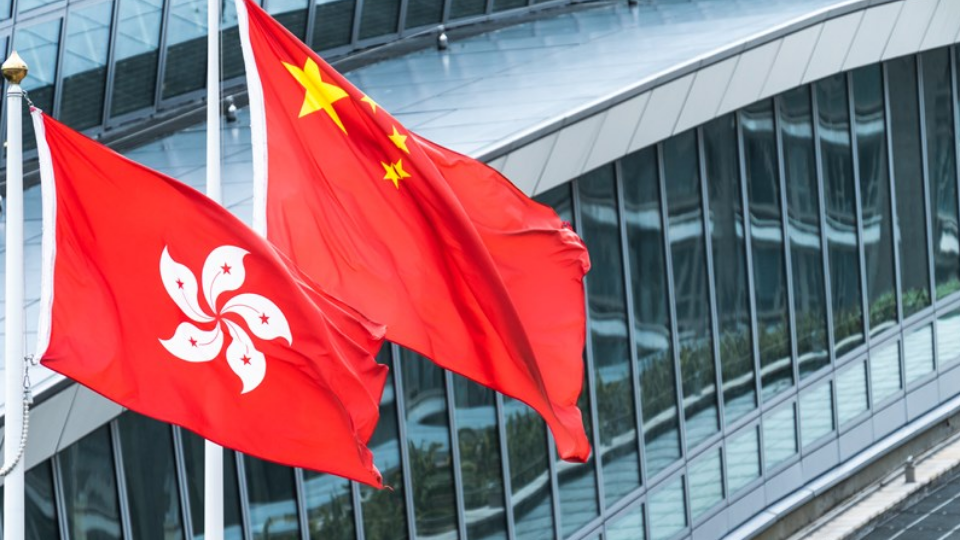Hong Kong and mainland China national flags stand together with copy space