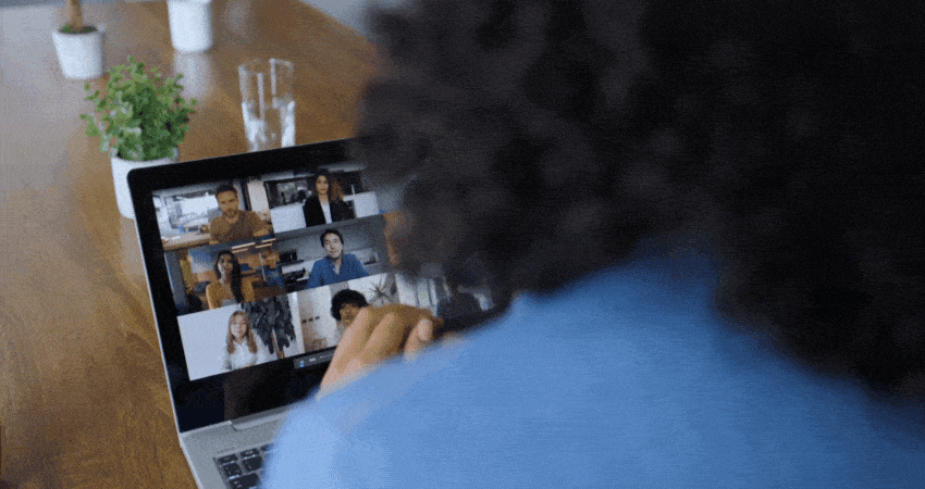 Unrecognizable woman at the office in a video call with her team