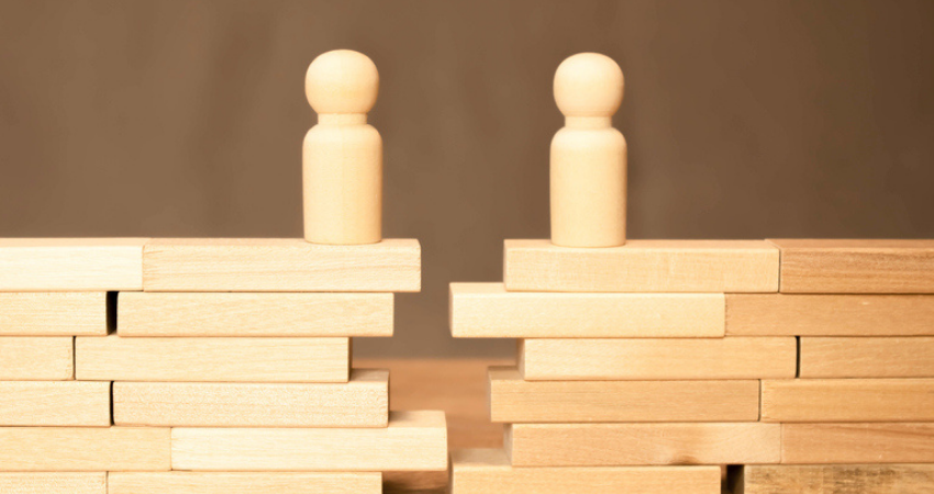 wooden people blocks across form each other