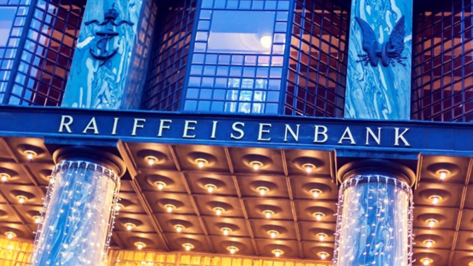 Looshaus with the Raiffeisen Bank signage at dusk