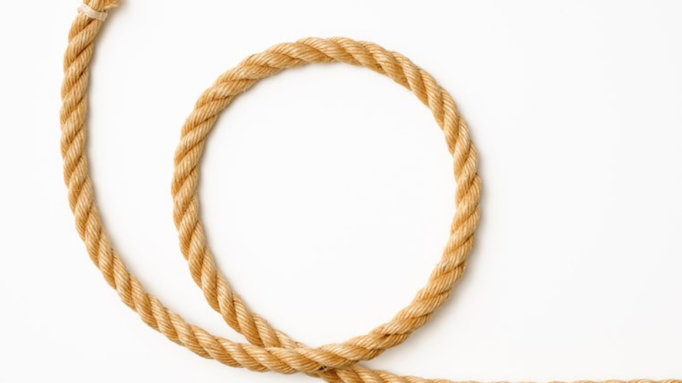 Isolated shot of loop of brown rope on white background