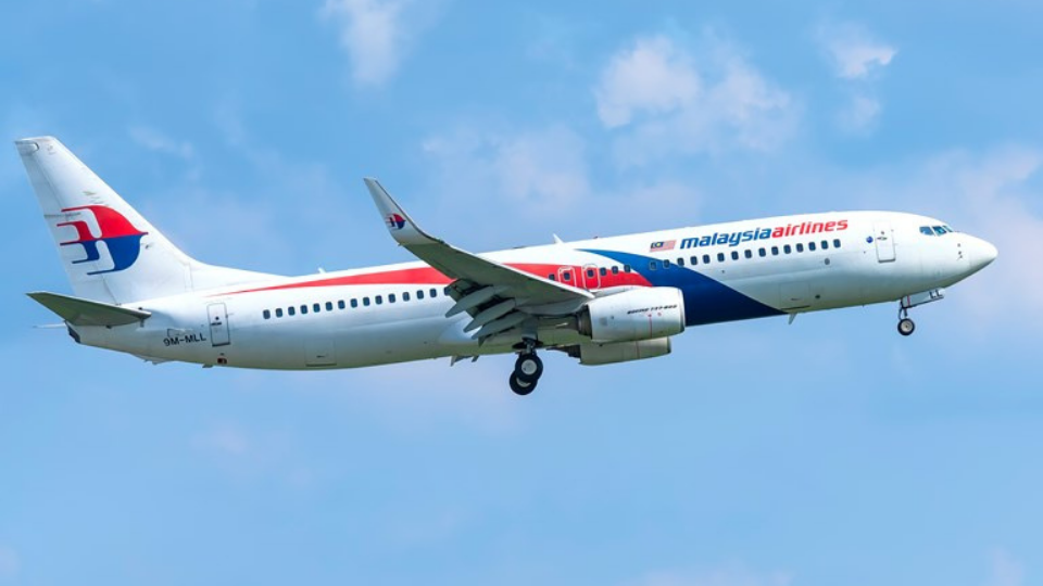 Airplane Boeing 737 of Malaysia Airlines flying through sky prepare to land
